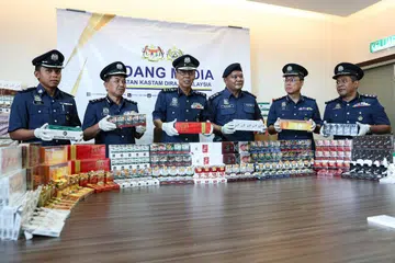 RAMPASAN ROKOK TERBESAR: Pengarah Jabatan Kastam Diraja Malaysia (JKDM) Perak, Datuk Abdul Ghafar Mohamad (tiga dari kiri), menunjukkan rokok pelbagai jenama yang dirampas.