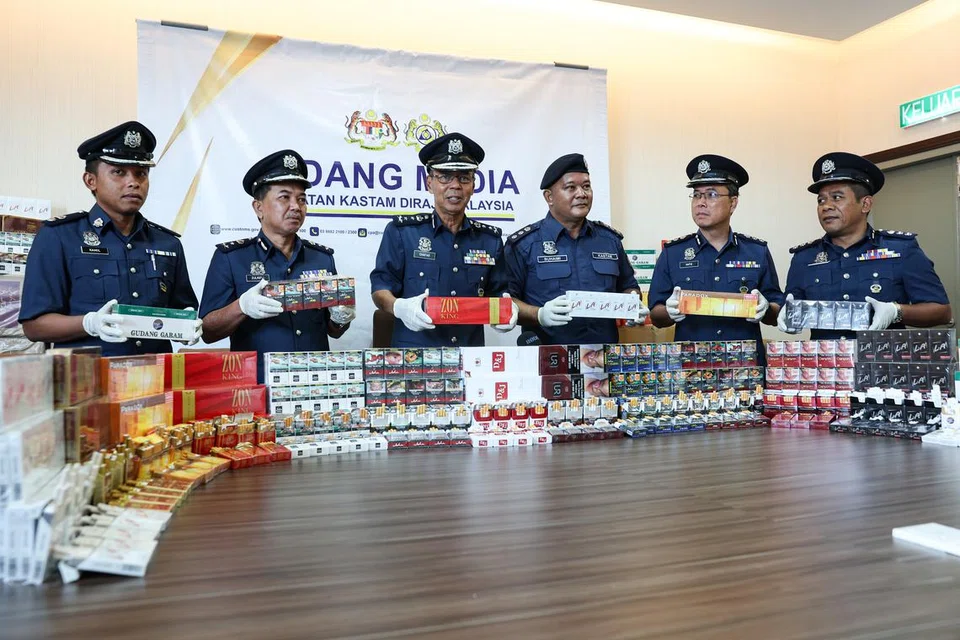 RAMPASAN ROKOK TERBESAR: Pengarah Jabatan Kastam Diraja Malaysia (JKDM) Perak, Datuk Abdul Ghafar Mohamad (tiga dari kiri), menunjukkan rokok pelbagai jenama yang dirampas.