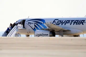 BEBAS: Beberapa penumpang kelihatan turun daripada pesawat EgyptAir yang dipaksa mendarat di Lapangan Terbang Larnaca di Cyprus. - Foto AFP