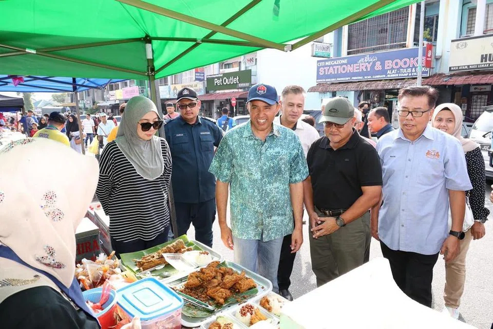 Pengerusi Jawatankuasa Perumahan dan Kerajaan Tempatan Johor, Datuk Mohd Jafni Md Shukor, menyantuni peniaga di bazar Bandar Baru Uda di Johor Bahru, pada 12 Mac petang.