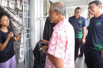 AGIH DAGING KORBAN: Menteri Bertanggungjawab bagi Ehwal Masyarakat Islam, Encik Masagos Zulkifli Masagos Mohamad (tengah), menyertai Ketua Eksekutif Majlis Ugama Islam Singapura (Muis), Encik Kadir Maideen (kanan), dan sekitar 50 sukarelawan bagi mengagih daging korban kepada penerima Projek DIAN@M3 di Eunos Crescent.
