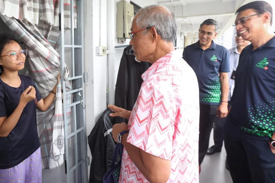 AGIH DAGING KORBAN: Menteri Bertanggungjawab bagi Ehwal Masyarakat Islam, Encik Masagos Zulkifli Masagos Mohamad (tengah), menyertai Ketua Eksekutif Majlis Ugama Islam Singapura (Muis), Encik Kadir Maideen (kanan), dan sekitar 50 sukarelawan bagi mengagih daging korban kepada penerima Projek DIAN@M3 di Eunos Crescent.