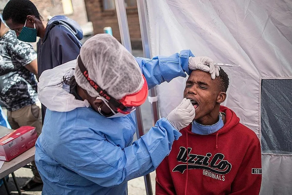 UJIAN: Jururawat Doctors Without Borders (MSF) Bhelekazi Mdlalose melakukan ujian Covid-19 semasa pemeriksaan dan ujian Kementerian Kesihatan di asrama lelaki Wolhuter di daerah Jeppestown, Johannesburg, pada 14 Mei. - Foto AFP