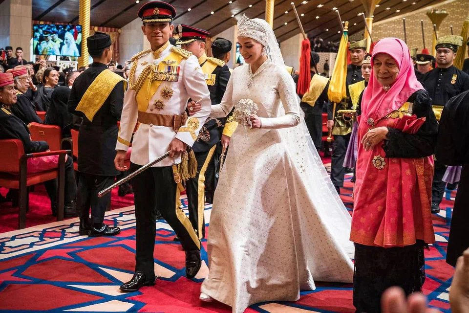 UPACARA GEMERLAPAN: Putera Abdul Mateen (kiri) dan Dayang Anisha Rosnah berjalan menuju ke pelamin ketika majlis perkahwinan mereka di Istana Nurul Iman di Bandar Seri Begawan, Brunei.