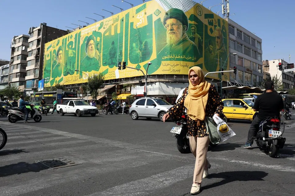 Seorang wanita Iran berjalan di hadapan papan iklan memaparkan gambar Allahyarham Pemimpin Tertinggi Iran, Ayatollah Ali Khamenei (tengah), dan pemimpin Hamas di Teheran, Iran, pada 6 Oktober 2026. Ketegangan Amerika Syarikat-Iran berterusan ketika Rumah Putih dilaporkan meminta Pentagon menyediakan pilihan bagi kemungkinan serangan baru ke atas Iran.