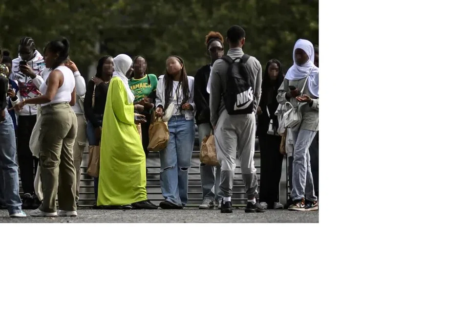SERING DISALAH ANGGAP: Seorang wanita muda memakai abaya (tengah) menjelaskan kepada beberapa orang di Nantes, barat Perancis, mengenai pakaian Muslimah, yang sering disalah anggap. 