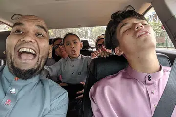 RINDU ANAK BUAH: Cef Bob (kiri) biasanya memandu kereta membawa anak-anak saudara berjalan Raya tapi amalan itu tidak dapat dilakukan tahun ini. Gambar diambil tahun lalu. - Foto ihsan SHAHRIZAL SALLEH