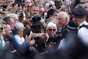 TEMU RAKYAT: Raja Charles III menerima sorakan ketika bersalaman dengan orang ramai di luar Istana Buckingham sekembali baginda dari Scotland, di mana Ratu Elizabeth II meninggal dunia pada usia 96 tahun. - Foto REUTERS 