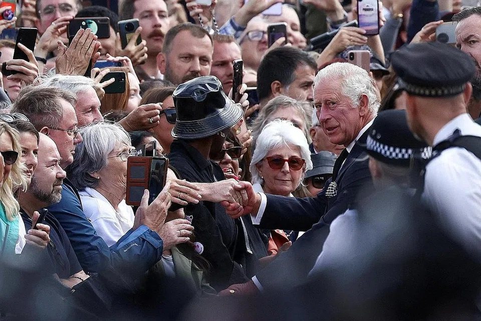 TEMU RAKYAT: Raja Charles III menerima sorakan ketika bersalaman dengan orang ramai di luar Istana Buckingham sekembali baginda dari Scotland, di mana Ratu Elizabeth II meninggal dunia pada usia 96 tahun. - Foto REUTERS 