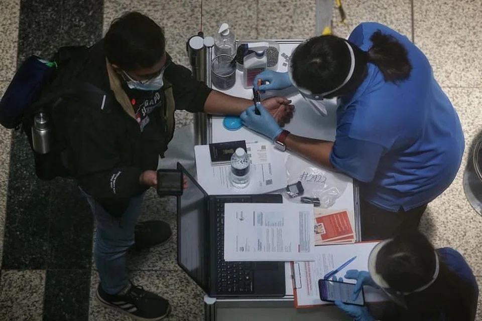 KETETAPAN NOTIS JANGAN KELUAR RUMAH: Seorang pengembara diberi 'smartwatch' Notis Jangan Keluar Rumah (SHN) yang dikeluarkan Kementerian Tenaga Manusia (MOM) setibanya di Lapangan Terbang Changi pada 24 September lalu. Mulai 4 November, pengunjung daripada lebih banyak negara akan dibenarkan menjalani SHN di tempat tinggal mereka sendiri setibanya di Singapura. - Foto BH oleh KEVIN LIM 