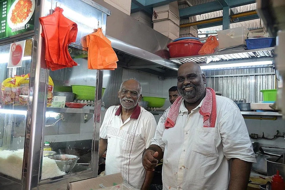RESIPI TURUN-TEMURUN: Encik Meeran Gani (kiri) dan anaknya Encik Muzamil Meerangani sewaktu bertugas di gerai mereka di 58 Upper Changi Road. - Foto BM oleh HARITH MUSTAFFA.