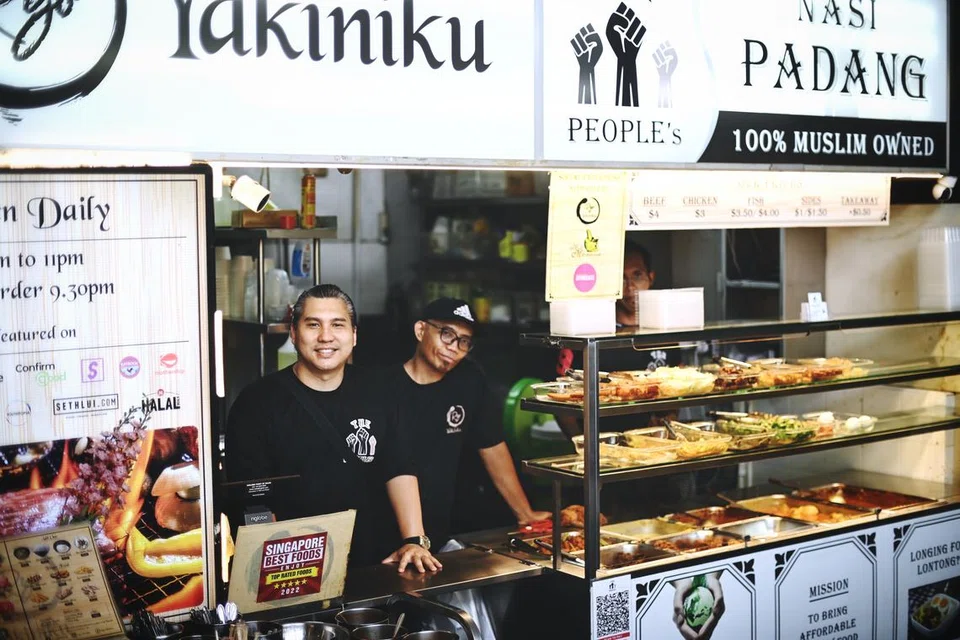 Encik Ismail Didih Ibrahim (kiri) kini menguruskan gerai ‘People’s Nasi Padang’ dan ‘Rio Yakiniku’ di 61 Tai Seng Avenue, menggajikan bekas pesalah seperti Encik Nizam Dardari (kanan) bagi mereka meraih pengalaman dan kemahiran menguruskan cawangan makanan dan minuman (F&B).