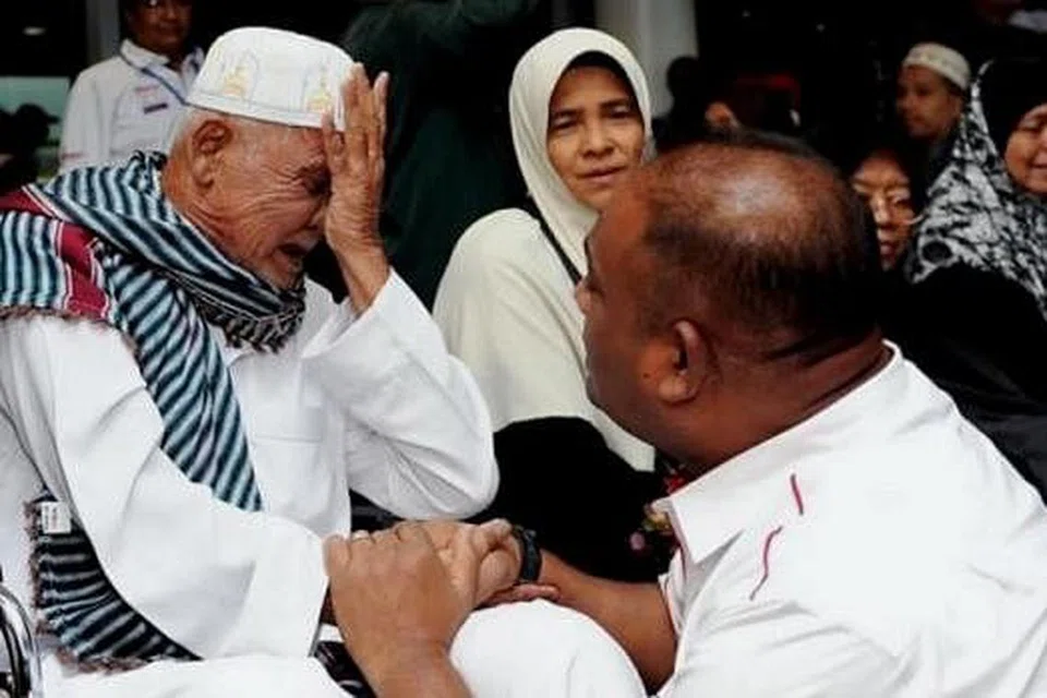 SEDIH: Encik Johari Chik (kiri) kesedihan mengenang pengalamannya terkandas di Madinah selepas menunaikan umrah. Beliau ditenangkan oleh Ketua Biro Kebajikan Umno, Datuk Seri Abdul Azeez, sejurus tiba di KLIA dari Arab Saudi. - Foto THE STAR