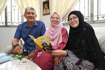 MENGUBAT RINDU: (Dari kiri) Encik Amirudhin, Cik Azizah dan Cik Sapiyah yang bakal menunaikan umrah hujung tahun ini dijangka mengikuti rombongan Shahidah Travel and Tours. Mereka akan ke Madinah selama lapan hari dan kemudian ke Makkah selama lima hari. - Foto BH oleh KHALID BABA