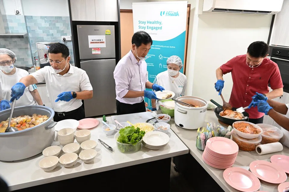 MENTERI SEDIA KE DAPUR: (Dari kiri) Menteri Pembangunan Negara, Encik Desmond Lee; Menteri Kesihatan, Encik Ong Ye Kung; dan Pemangku Menteri Pengangkutan, Encik Chee Hong Tat bantu warga emas memasak di Dapur Komuniti Kesihatan NTUC di Lengkok Bahru pada Khamis.