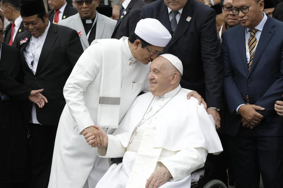 Imam Besar Masjid Istiqlal, Profesor Dr. H. Nasaruddin Umar (kiri), berjabat tangan sambil mencium dahi Paus Francis selepas satu pengisytiharan yang ditandatangani bersama di Masjid Istiqlal di Jakarta, Indonesia pada 5 September 2024. 
