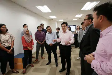 BERAMAH MESRA: Encik Heng Swee Keat (tiga dari kanan) beramah mesra dengan kakitangan BH dalam lawatannya ke bilik berita BH semalam. Beliau ditemani Encik Saat A. Rahman (empat dari kanan), Encik S. Iswaran (dua dari kiri) dan Encik Zaqy Mohamad (kanan). - Foto BH oleh JASON QUAH
