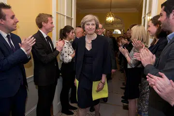MULAKAN TUGAS: Kakitangan di 10 Downing Street menyambut ketibaan Perdana Menteri Britain yang baru, Cik Theresa May (depan, tengah), dan suaminya Encik Philip (belakang), selepas mereka bertemu dengan Ratu Elizabeth di Istana Buckingham pada Rabu lalu. - Foto REUTERS