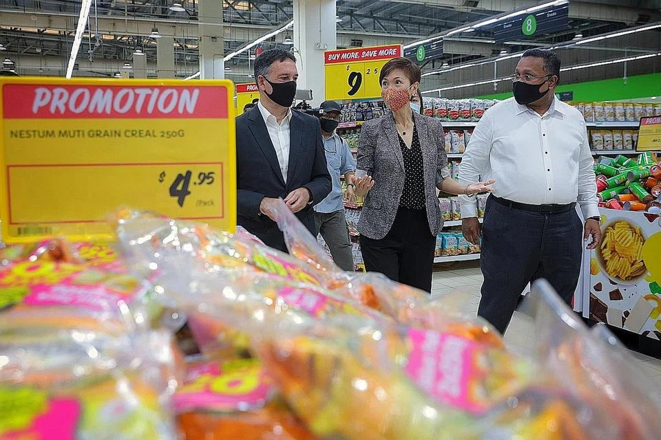 PASARAN BURUH ANSUR PULIH: Cik Teo, yang diiringi Ketua Pegawai Eksekutif SEA Food, Dairy Farm, Encik Chris Bush (kiri), dan Pengarah Operasi di Giant, Encik Maheswaran Thambunathan, telah mengunjungi Giant Hypermarket di Tampines semalam. - Foto BH oleh JASON QUAH