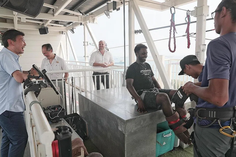 SOKONGAN BAGI PENIAGA: Encik Chee (paling kiri) bertemu kakitangan dan pemilik AJ Hackett Bungy di Sentosa semalam, antara beberapa perniagaan di sini yang terjejas akibat penularan Covid-19. - Foto BH oleh JASON QUAH