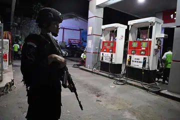 BUAT KAWALAN: Seorang pegawai polis mengawal sebuah stesen minyak di Jayapura, Papua. - Foto REUTERS