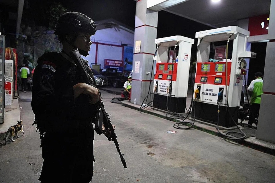 BUAT KAWALAN: Seorang pegawai polis mengawal sebuah stesen minyak di Jayapura, Papua. - Foto REUTERS