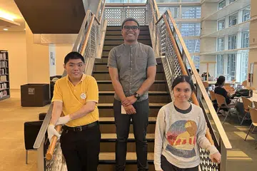 Pembantu perkhidmatan perpustakaan, Encik K. R. Teh (kiri) dan Cik Yeo Hui Qing (kanan), bersama penyelia mereka, Encik Muhammad Iqbal Buang. Kedua-dua individu yang menghidap autisme itu adalah antara 29 individu kurang upaya yang diambil bekerja oleh Certis pada Ogos. 