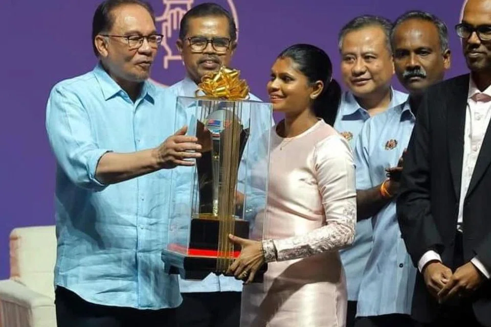 Dr Mala Santhi Santherasegapan (tengah) menerima Anugerah Pekerja Contoh sempena sambutan Hari Pekerja pada 2023, dengan piala penghormatan disampaikan oleh Perdana Menteri Malaysia, Datuk Seri Anwar Ibrahim (kiri).