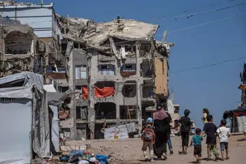 Penduduk Palestin yang kehilangan tempat tinggal berjalan berhampiran bangunan kediaman yang musnah di utara Gaza City pada 20 September. PBB memberi amaran ratusan bangunan yang rosak akibat perang masih berisiko runtuh, sedang pihak berkuasa Gaza melancarkan pelan kecemasan untuk mengosongkan dan merobohkan 255 bangunan berbahaya.