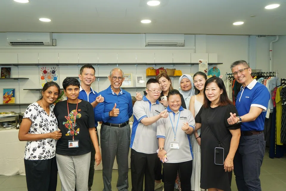 Pengerusi Lembaga Persatuan Golongan Kurang Daya Intelek Singapura (Minds), Encik Geoffrey Ong (tiga dari kiri); Menteri Pembangunan Sosial dan Keluarga, Encik Masagos Zulkifli Masagos Mohamad (empat dari kiri); dan Ketua Pegawai Eksekutif  (CEO) Minds, Encik Kelvin Koh (kanan), bersama golongan kurang daya intelek (PWID) dan keluarga mereka di Minds Oasis@Hougang, ruang sosial untuk penduduk di kawasan kejiranan itu untuk menghabiskan masa bersama PWID.