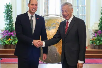 KUNJUNGAN DIRAJA: Putera William (kiri) disambut Perdana Menteri, Encik Lee Hsien Loong, setibanya beliau di Istana pada Isnin sebagai sebahagian daripada acara latawan kerjanya ke Singapura. 