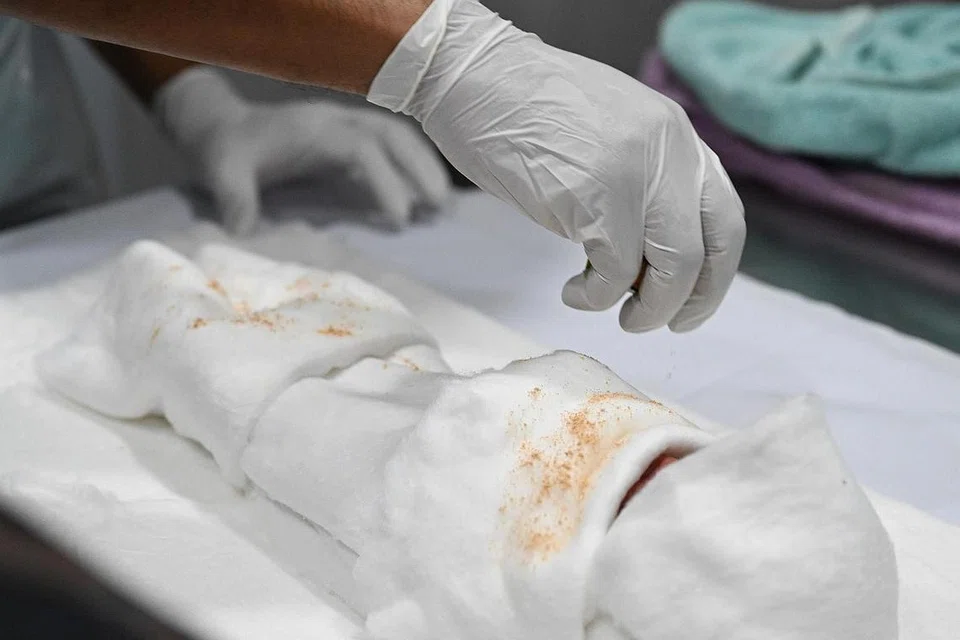 WANGI-WANGIAN: Sebagai sebahagian proses mengkafan, dibubuh minyak atar dan pacai untuk memberikan kewangian dan menjauhkan serangga daripada bayi itu. - Foto BM oleh KHALID BABA
