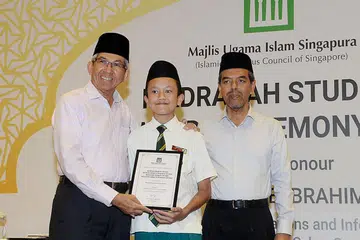 BIJAK ATUR JADUAL: Muhammad Safwan Rosli (tengah) menerima anugerah daripada Dr Yaacob Ibrahim (kiri) disaksikan Ketua Eksekutif Muis Haji Abdul Razak Maricar di majlis Anugerah Pelajar Madrasah. - Foto-foto JOHARI RAHMAT