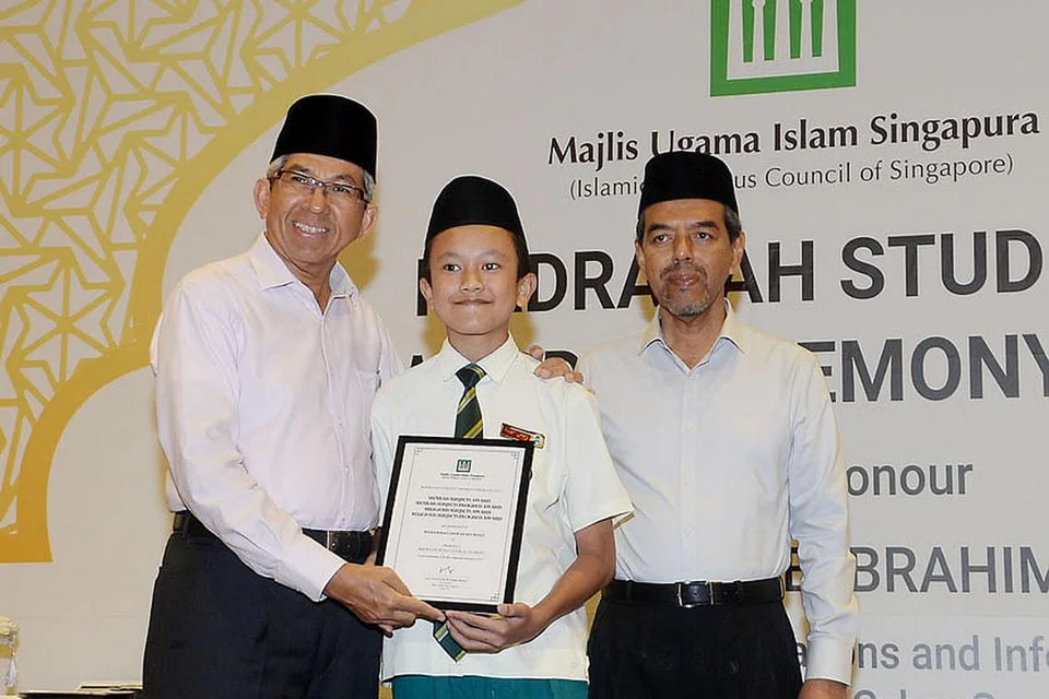 BIJAK ATUR JADUAL: Muhammad Safwan Rosli (tengah) menerima anugerah daripada Dr Yaacob Ibrahim (kiri) disaksikan Ketua Eksekutif Muis Haji Abdul Razak Maricar di majlis Anugerah Pelajar Madrasah. - Foto-foto JOHARI RAHMAT