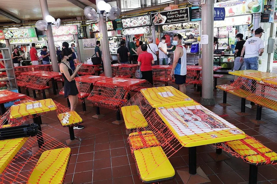 BUNGKUS SINI SANA: Kerusi meja di pusat makanan di merata Singapura 'dibungkus' kerana orang ramai tidak dibenarkan makan di luar sepanjang tempoh P2HA. Para peniaga makanan turut terjejas kerana terpaksa menanti pelanggan yang hanya boleh beli makanan bungkus untuk dibawa pulang. - Foto BM oleh KELVIN CHNG