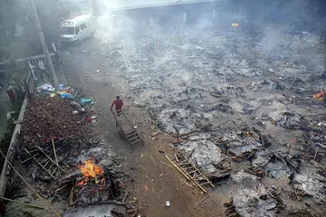 PEMBAKARAN TERBUKA: Disebabkan kekurangan pusat pembakaran mayat, keluarga melakukan pembakaran mayat saudara mereka yang terkorban akibat Covid-19 di tempat terbuka menggunakan kayu api di New Delhi. - Foto EPA-EFE