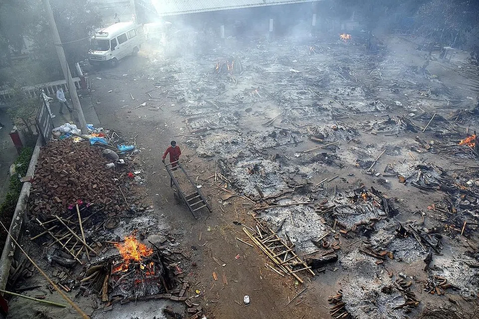 PEMBAKARAN TERBUKA: Disebabkan kekurangan pusat pembakaran mayat, keluarga melakukan pembakaran mayat saudara mereka yang terkorban akibat Covid-19 di tempat terbuka menggunakan kayu api di New Delhi. - Foto EPA-EFE