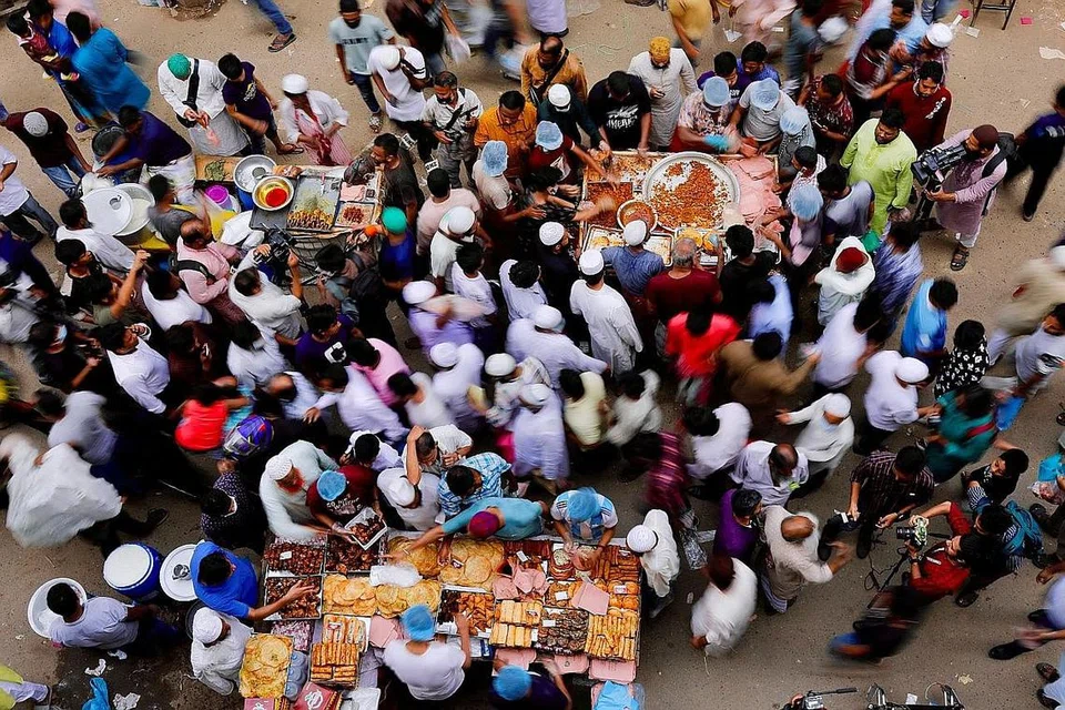 BEREBUT MEMBELI: Orang ramai mengerumuni beberapa kedai di pasar Chawkbazar untuk membeli makanan untuk berbuka puasa, di Dhaka, Bangladesh. - Foto REUTERS 