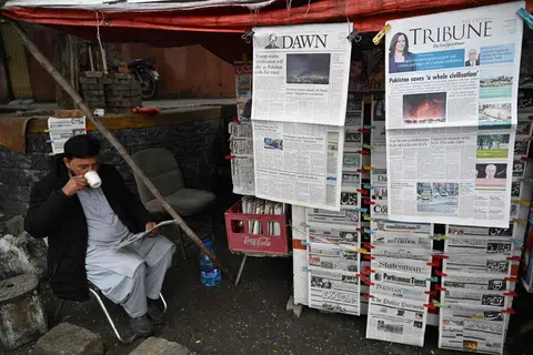 Seorang penjual minum teh sambil membaca akhbar pagi di sebuah gerai tepi jalan di Islamabad pada 8 April 2026. Perdana Menteri Pakistan, Shehbaz Sharif, berkata Amerika Syarikat, Iran dan sekutu mereka telah bersetuju melaksanakan gencatan senjata “di semua kawasan”, termasuk Lebanon, susulan usaha pengantaraan oleh kerajaannya untuk menghentikan pertempuran selama beberapa minggu.
