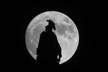 BULAN PALING BESAR: 'Supermoon' yang dilihat di sebalik Statue of Freedom di Capital Dome di Washington, DC, pada malam Ahad lalu. Bulan penuh itu berada di jarak paling dekat dengan bumi sejak 68 tahun lalu malam tadi dengan hanya sekitar 356,500 kilometer antara bulan dengan bumi. - Foto AFP