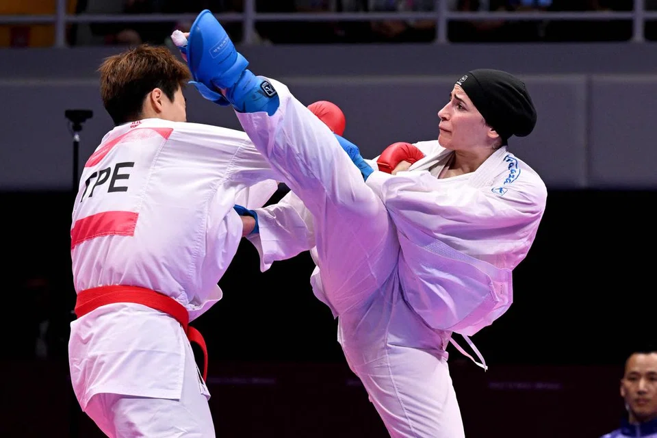 IMPIKAN KEDAMAIAN: Hala Alqadi (kanan) berkata beliau impikan pengakhiran kepada perang di Gaza dan kedamaian yang berkekalan bagi negaranya itu. Alqadi ketika bertemu atlet Taiwan, Chao Jou, dalam pertandingan Kumite wanita 68 kilogram di Sukan Asia, Hangzhou, China. 