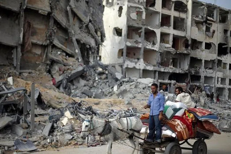 KESAN SERANGAN ISRAEL: Rakyat Palestin melihat kemusnahan bangunan semasa pulang ke bandar Beit Lahiya town di utara Carikan Gaza. - Foto AFP