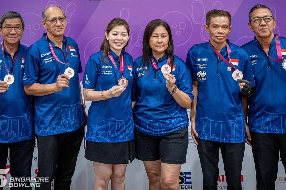 Pemain boling Singapura (dari kiri) Philip Tang, Adam Chew, Karen Song, Jessie Lim, Hairon Awang, dan Paiman Dali, raih pingat dalam acara beregu untuk tiga divisyen berbeza iaitu lelaki lebih senior, lelaki senior, dan wanita senior.