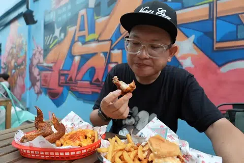Mohd Sufian Abdullah atau lebih dikenali sebagai Pian Padu Beb Studios ketika mencuba ayam goreng pedas di kedai Chix Hot Chicken di Arab Street, Singapura. 