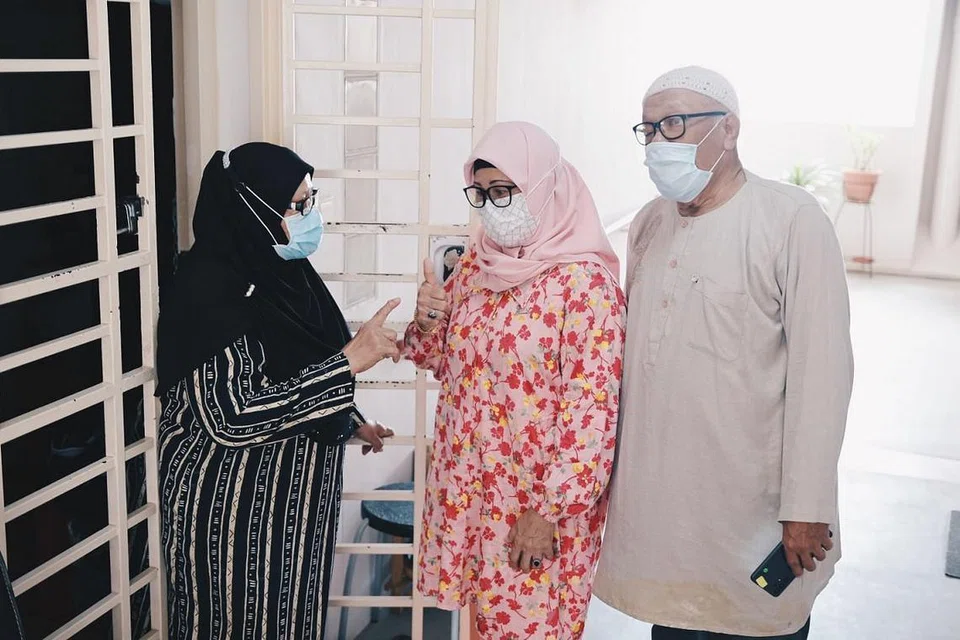 GALAK JIRAN AMBIL VAKSIN: Cik Norinin Salleh (paling kiri)) akhirnya mendapatkan suntikan vaksin pertamanya selepas diberi kata-kata semangat oleh jirannya, Cik Rosnah Khalid dan Encik Kamuri Sichor, yang mengambil berat tentangnya kerana beliau tinggal seorang di flat studionya di Tampines. - Foto BH oleh HARITH MUSTAFF