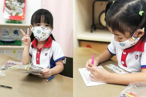 DAPAT MANFAAT: Murid prasekolah Yayasan Masyarakat PAP (PCF) memakai pelitup daripada fabrik dan mewarna poskad untuk kakitangan dan penghuni Orange Valley. - Foto ORANGE VALLEY NURSING HOMES