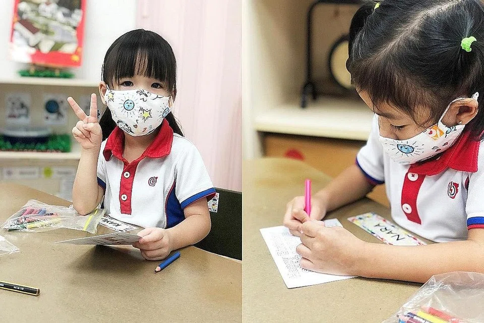 DAPAT MANFAAT: Murid prasekolah Yayasan Masyarakat PAP (PCF) memakai pelitup daripada fabrik dan mewarna poskad untuk kakitangan dan penghuni Orange Valley. - Foto ORANGE VALLEY NURSING HOMES