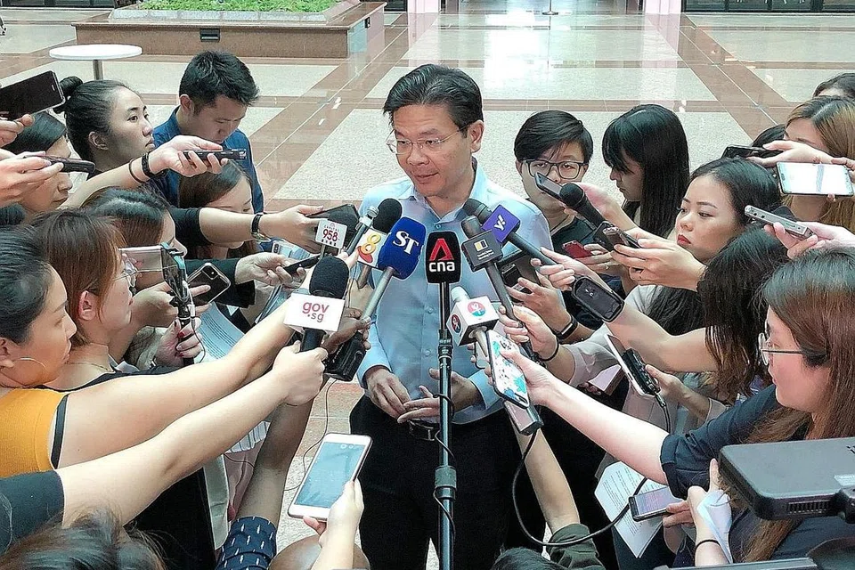 TINGKAT PERSIAPAN: Encik Lawrence Wong (tengah) bercakap kepada wartawan di luar Pusat Akhbar Nasional semalam. Kata Encik Wong, Singapura perlu bersiap menghadapi kes Covid-19 baru, sebagaimana yang sedang berlaku di serata dunia. - Foto BH oleh DESMOND WEE