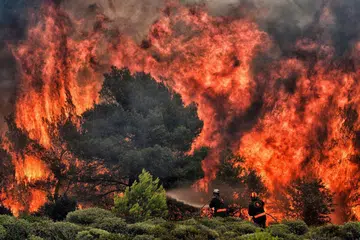 ANGKARA CUACA TERLALU PANAS: Kebakaran liar akibat cuaca panas di kampung Kineta, dekat Athens, Julai lalu membunuh 74 orang dan memusnahkan rumah serta hutan. - Foto AFP