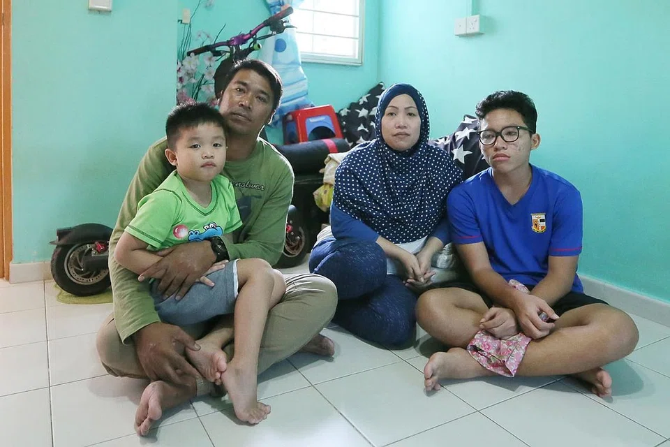 SYUKUR DAPAT BANTUAN: Cik Norainni Mes Adi bersama suami, Encik Roslan Aman, dan dua anaknya, Muhamad Indra Ilhan (paling kanan) dan Muhamad Daniel Rafael (atas pangkuan Encik Roslan) berharap dapat terus diberi sokongan menangani cabaran hidup. - Foto BH oleh JONATHAN CHOO